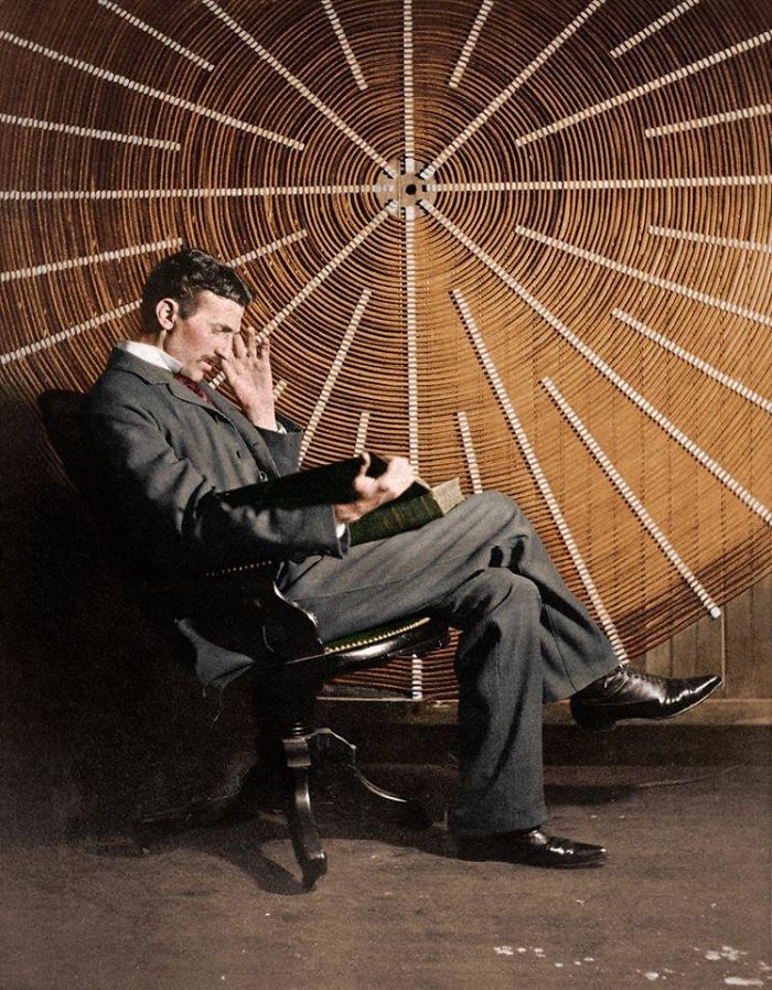 Nikola Tesla, leyendo 'Theoria Philosophiae Naturalis', frente a la bobina espiral de su transformador de alta frecuencia, en Nueva York