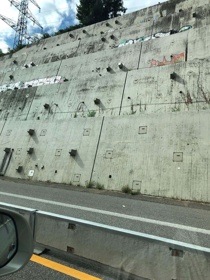 Swiss Autobahn Retaining Wall Has Square Protrusions And Panels That Look Like They Can Be Opened
