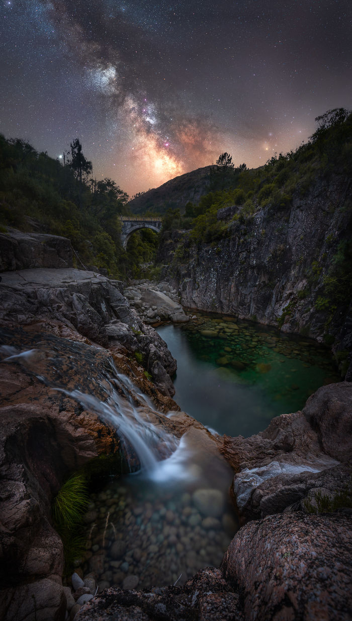 Night sky over a waterfall and rocky gorge in Madeira, showcasing the Milky Way and serene natural landscape.