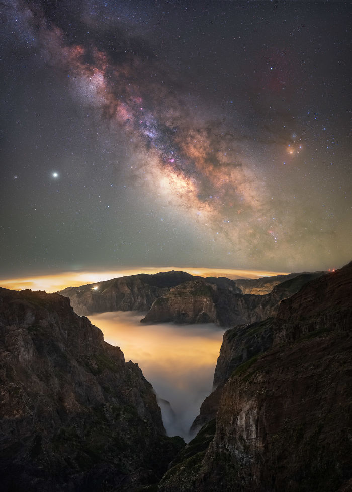Milky Way galaxy over Madeira mountains with fog filling the valley, showcasing a magical night sky landscape.