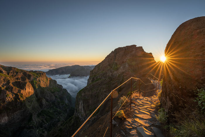 Sunrise over rocky cliffs and misty valleys in Madeira, capturing the island's magical natural beauty and stunning hiking trails.