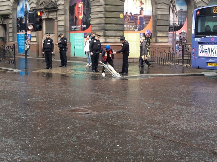 Just A Man Attempting To Vacuum A Puddle. Typical Glasgow
