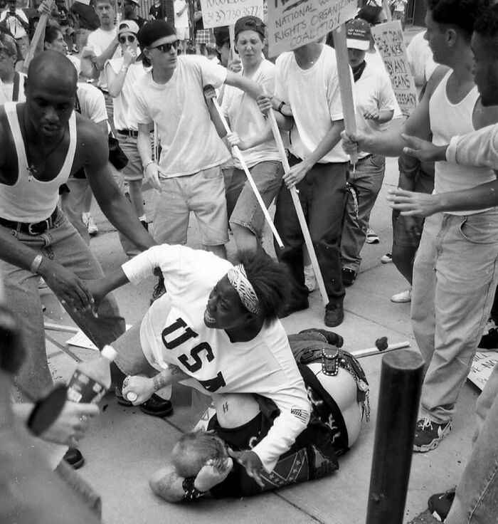Keshia Thomas de 18 años, protegiendo a un hombre caído asociado con el Ku Klux Klan, en una manifestación anti KKK. Michigan, 1996