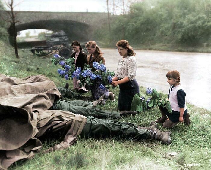 Three Young Russian Women And A Little Girl Recently Liberated From A Slave-Labor Camp By The U.S. Army Lay Flowers At The Feet Of Four Dead American Soldiers, April 18, 1945, Hilden, Germany