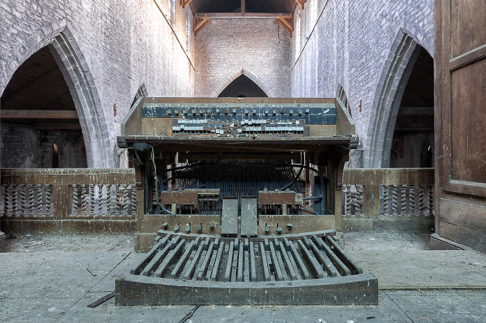 Rusty organ inside an abandoned church showing decay and history of forgotten European religious sites.