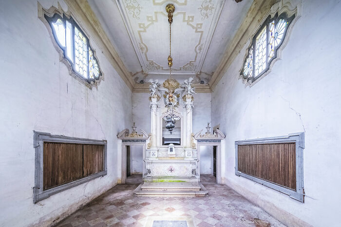 Interior of an abandoned church with ornate altar and stained glass windows, part of Europe travel discovery of abandoned churches.