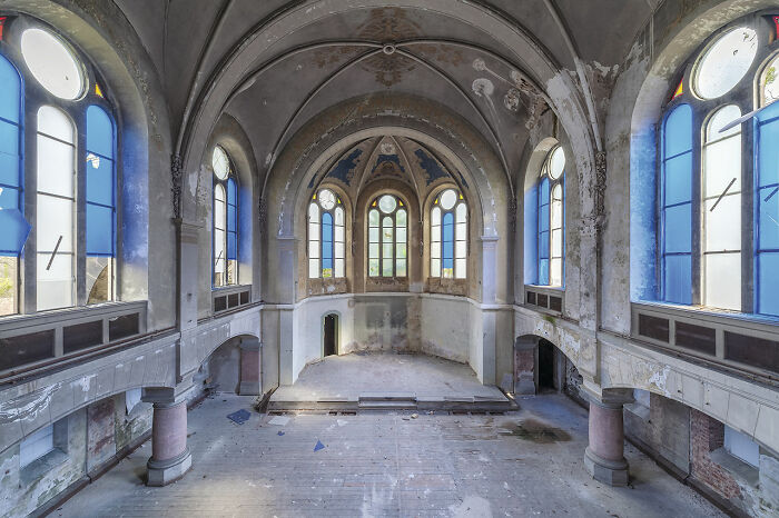 Abandoned church interior in Europe with tall arched windows and peeling paint discovered over eight years of travel