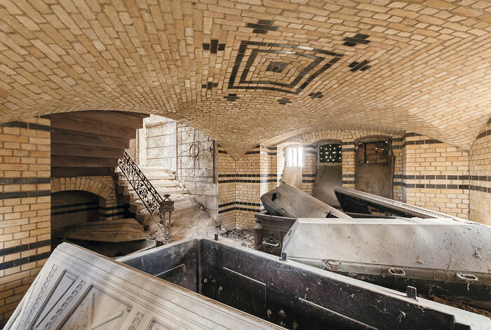Interior view of abandoned church crypt with old coffins and vaulted brick ceiling discovered during European travels.