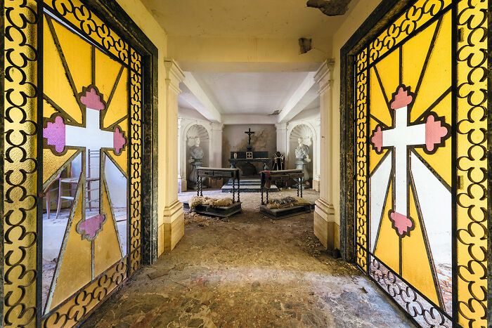 Interior view of an abandoned church in Europe with stained glass doors and worn altars discovered during extensive travel.
