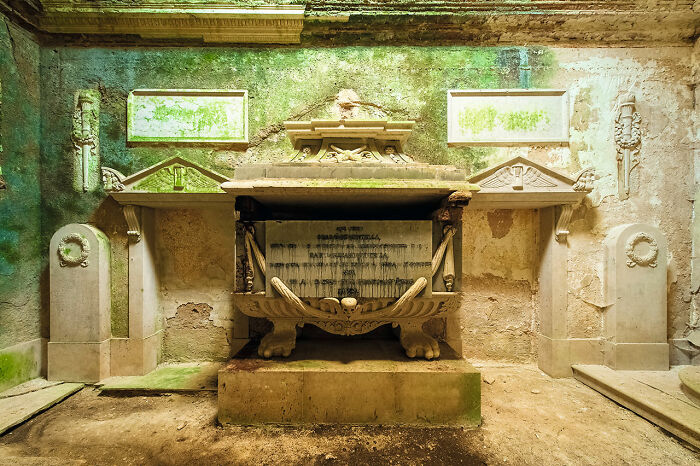 Interior of an abandoned church with ornate stone tombs and moss-covered walls discovered during European travels.