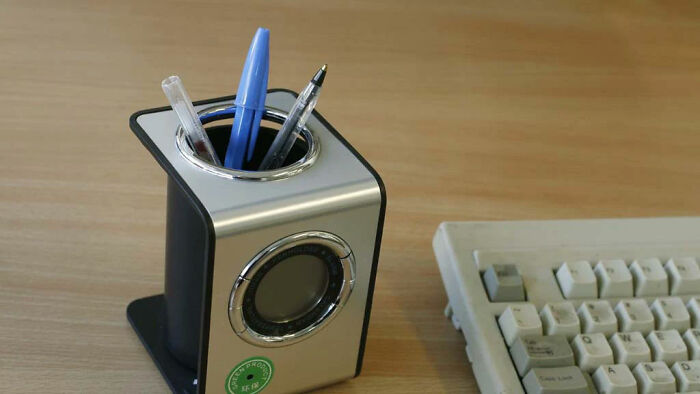 Camera Hidden In Pen Holder, With The Lens Seen In The Centre Of The Green Sticker