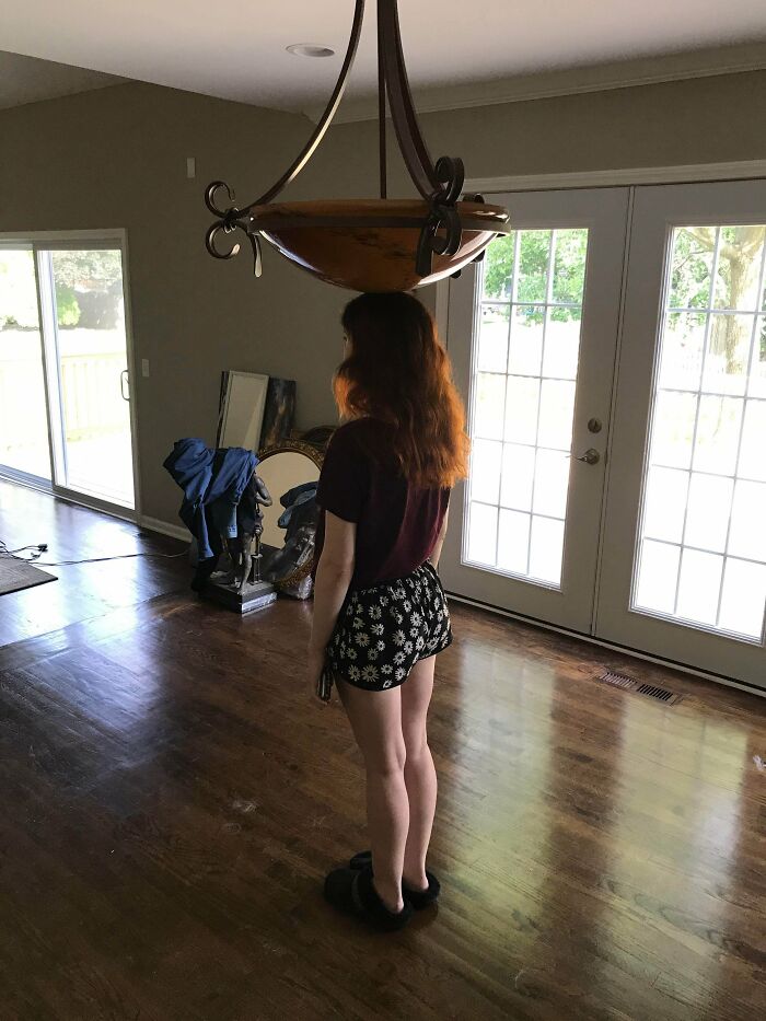 My Sister Under Our Dining Room Chandelier (Room Is Bare Because We’re Moving)
