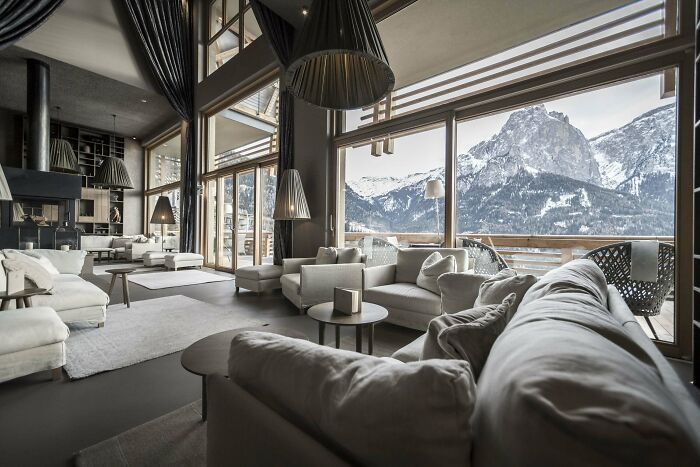 Tall And Spacious Hotel Lounge Centered Around A Fireplace With Stunning Views Of The Italian Dolomites, South Tyrol, Northern Italy