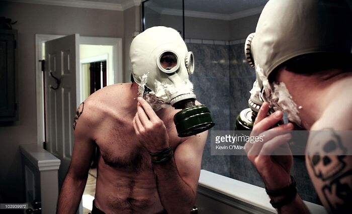 Man In Gas Mask Getting Ready To Shave