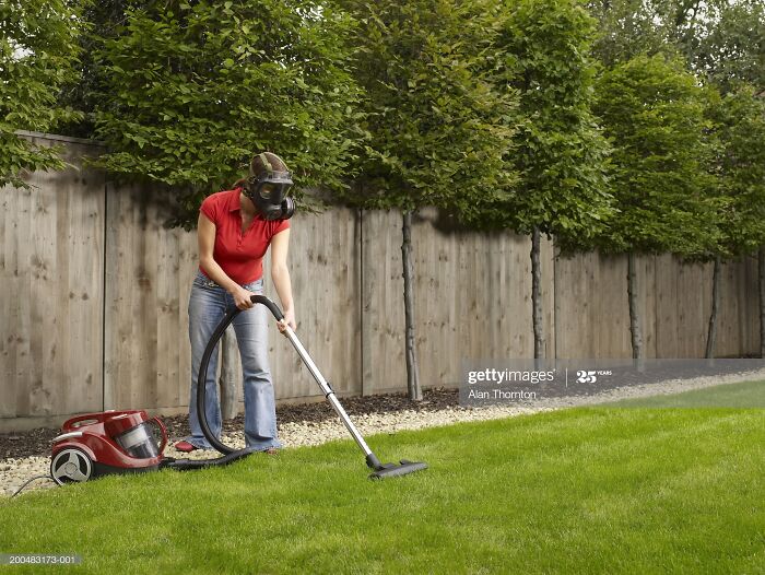 Woman Wearing Gas Mask Vacuuming Lawn