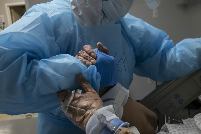 31 de Octubre. Trabajador médico dando la mano a un paciente de Covid mientras recoloca su cama