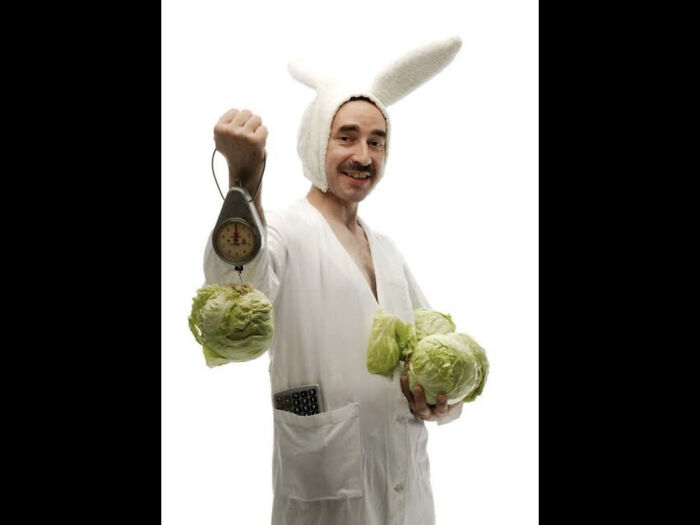 A Man Wearing Rabbit Ears Weighing Cabbages With A Calculator In His Coat/Robe... Makes Sense