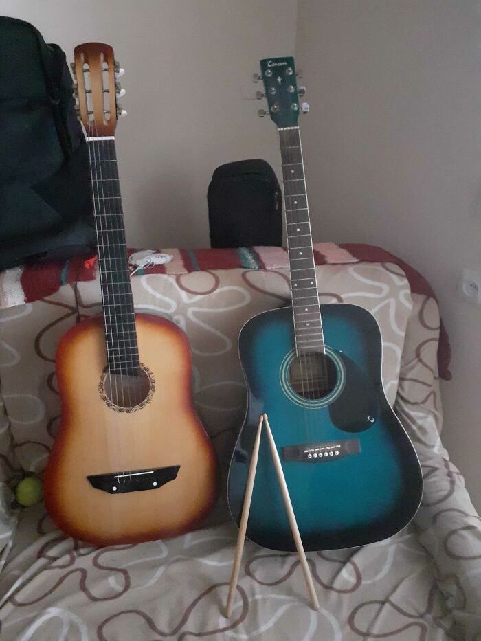 A Classic And An Acoustic Guitar And Practice Drum Sticks