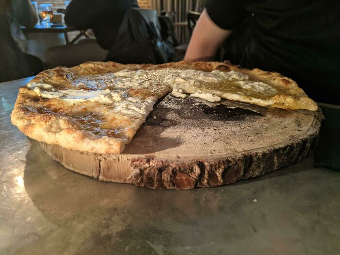 This Pizza Being Served On A Slice Of Tree