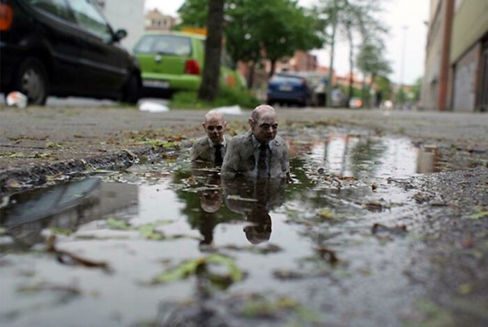 These Guys In The Middle Of The Sidewalk Coming Out Of A Puddle