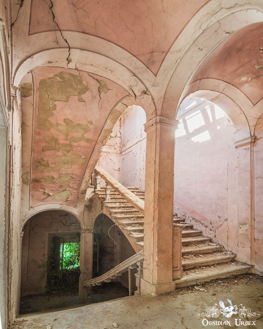 Delicate Pink Paint Peels From The Ceiling Above This Abandoned Staircase