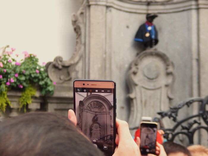 Taken In Brussels: A Funny Photo Of Tourists Who Are Photographing The Statue Of Manneken Pis.