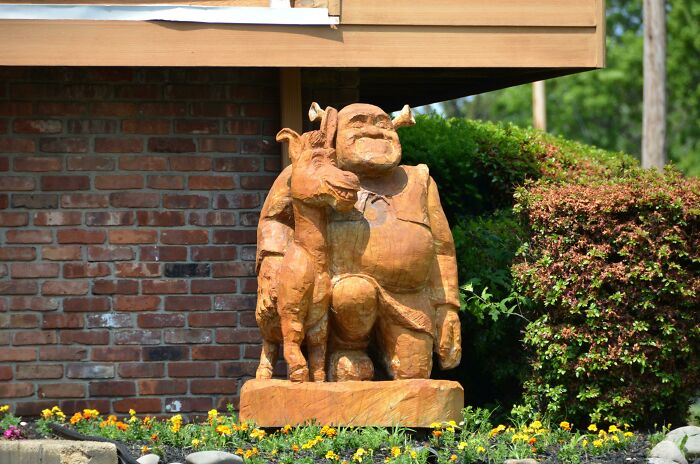 A Wooden Carving Of Shrek And Donkey In Front Of A House In Nj