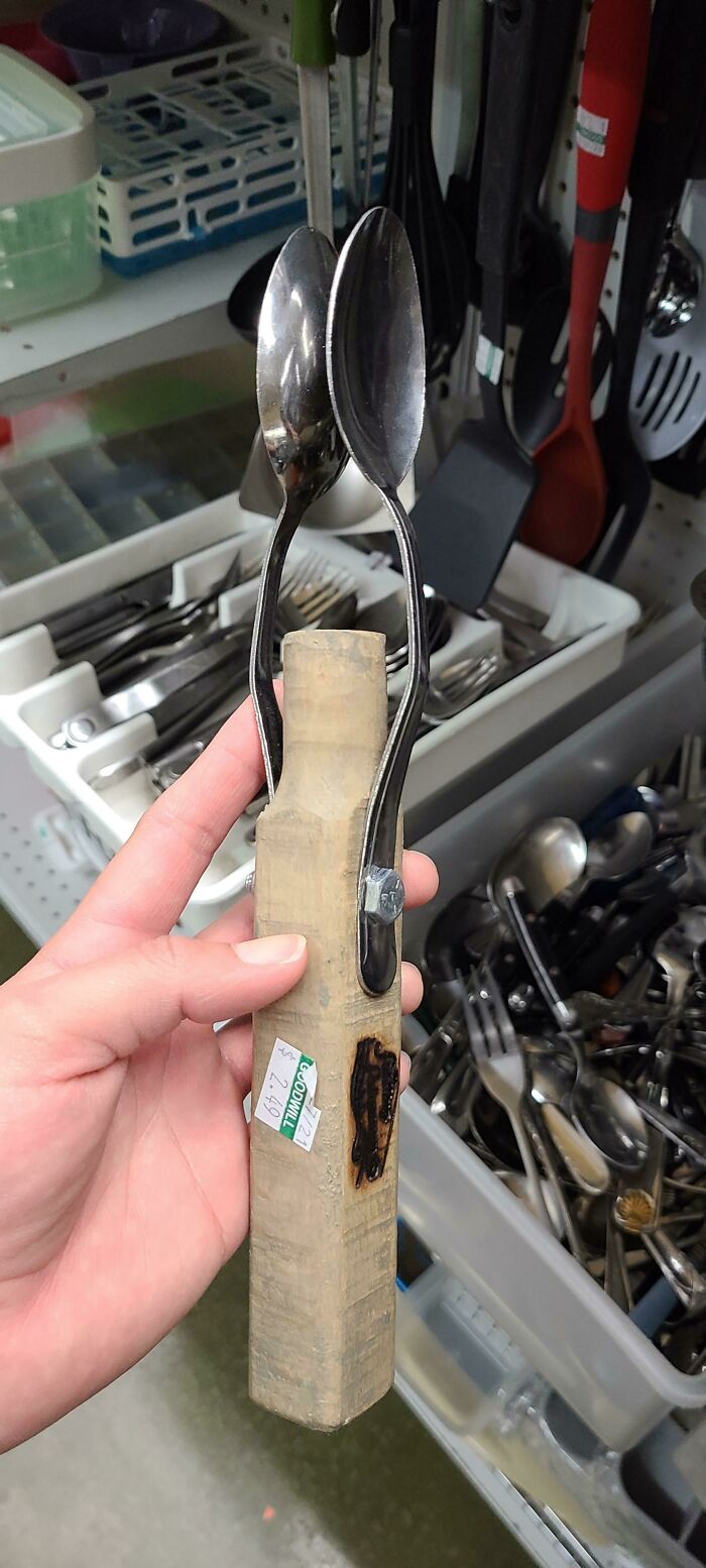¿Dos cucharas unidas a un mango de madera en la tienda de segunda mano?
