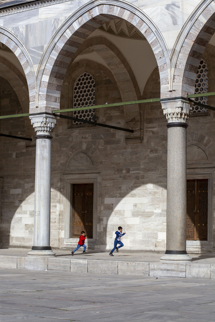 The Pillars Of The Suleymaniye Mosque And The Shadows Of The Arches Create Spectacular Frames Around The Kids Running And Playing Joyfully