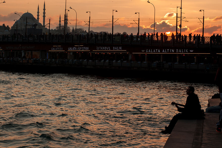 Whenever I Look At This Photo, I Can Hear The Music Of Istanbul. People At The Fish Restaurants Underneath The Bridge, The Fishermen, And The By-Passers On The Bridge, The Sound Of The Prayer Coming From The Mosque, And The Sound Of The Ferries And The Seagulls... The Music Of The Guitar Player Is Just Completing The Rhythm Of The City
