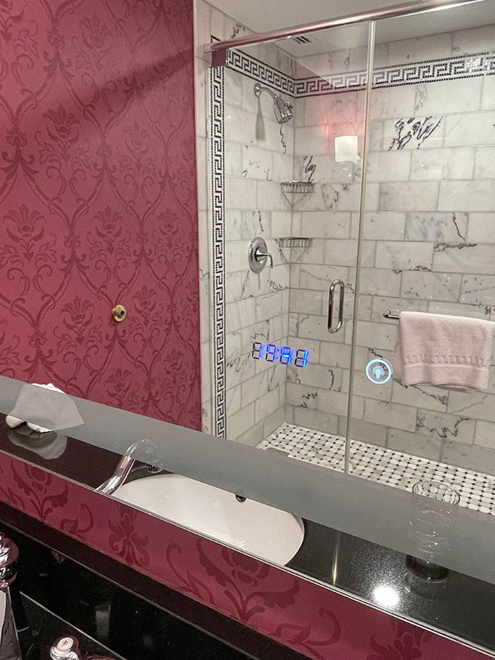 My Hotel Room’s Bathroom Mirror Has A Digital Clock Embedded In It