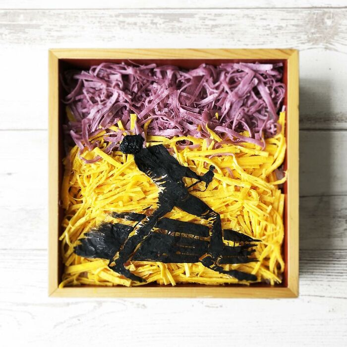Bento artist lunchbox featuring a detailed edible design of a silhouette character on shredded purple and yellow food background.