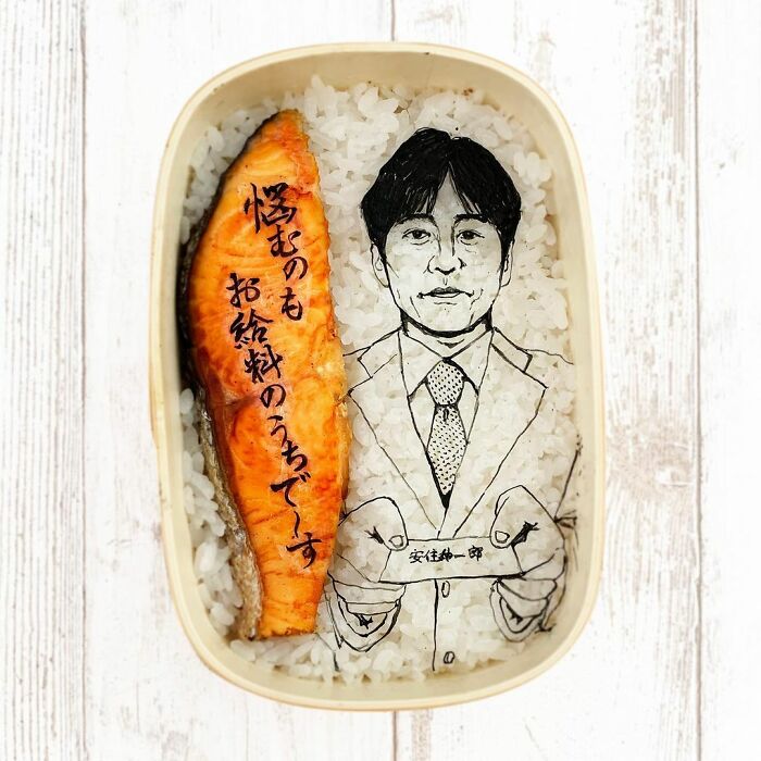 Bento artist creating detailed lunchbox portrait on rice with grilled salmon inspired by favorite TV shows and movies.