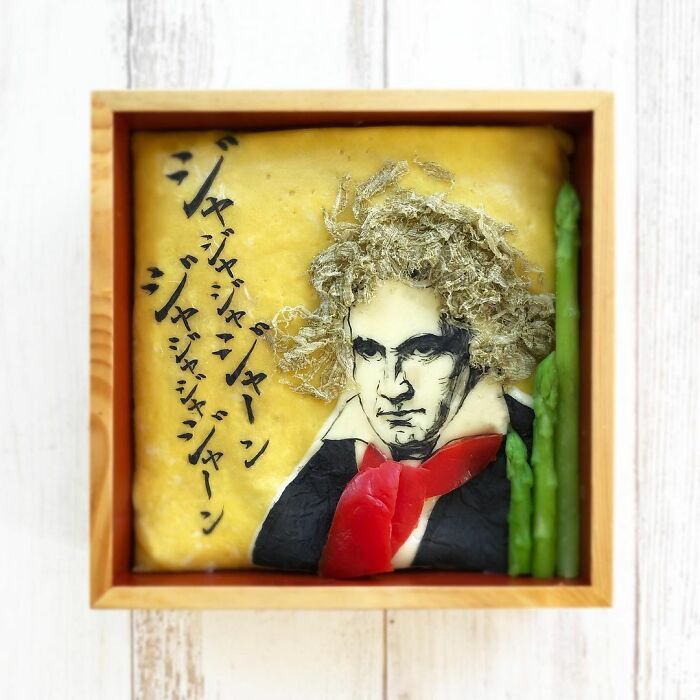 Bento artist’s detailed lunchbox featuring a portrait of Beethoven with asparagus and Japanese text decoration.