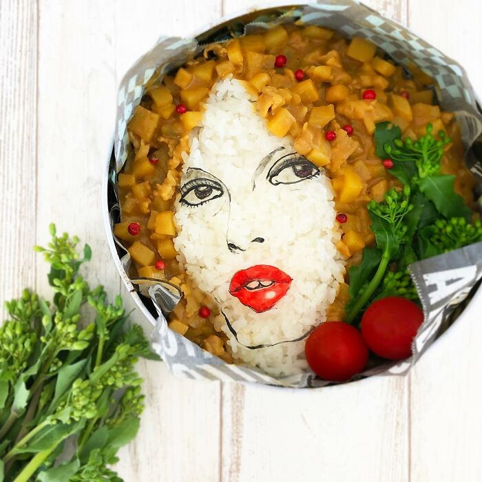 Bento artist creates a lunchbox featuring a detailed face design using rice, vegetables, and curry for her husband’s favorite shows.