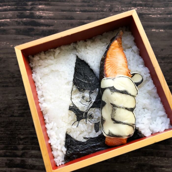 Bento artist creates detailed lunchbox with rice, seaweed, and salmon inspired by favorite TV shows and manga characters.