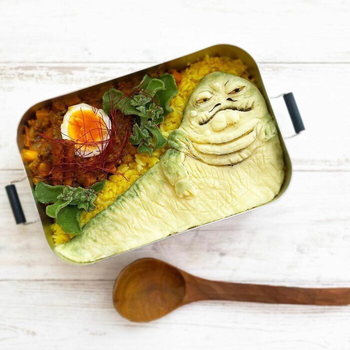Bento artist creates detailed lunchbox featuring Jabba the Hutt from Star Wars with rice, egg, and greens.