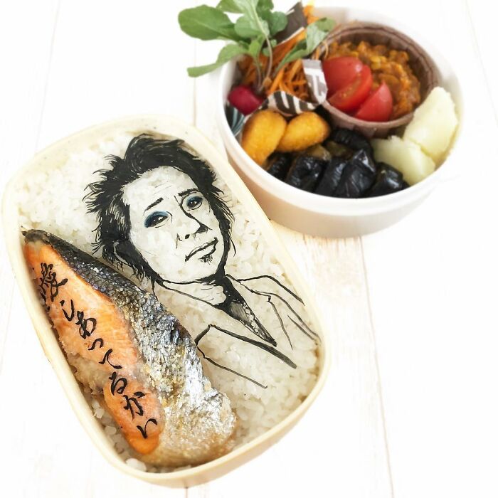 Bento artist creates detailed lunchbox featuring a portrait and salmon, inspired by favorite TV shows and manga.