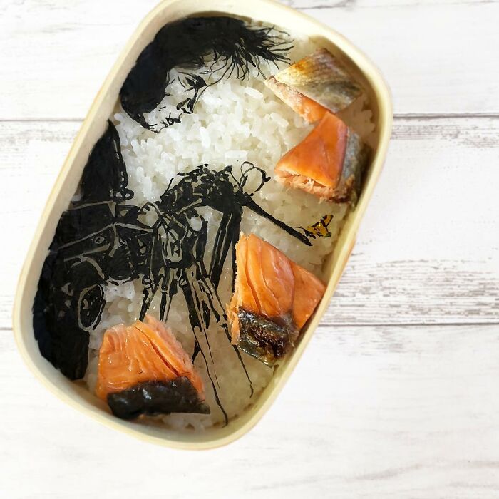 Bento artist creates detailed lunchbox with rice, salmon, and seaweed art inspired by favorite TV shows and manga.