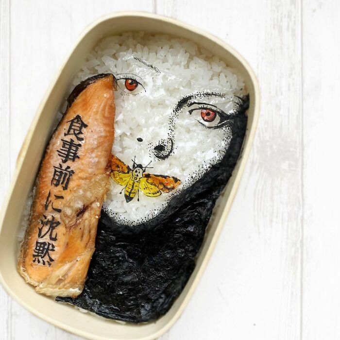 Bento artist creates detailed lunchbox art featuring a woman's face with a moth and Japanese characters on salmon.