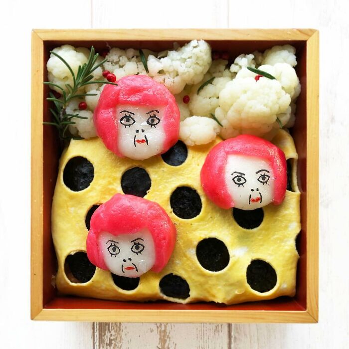 Bento artist creates detailed lunchbox featuring faces with red hair and cauliflower, inspired by favorite TV shows and manga.