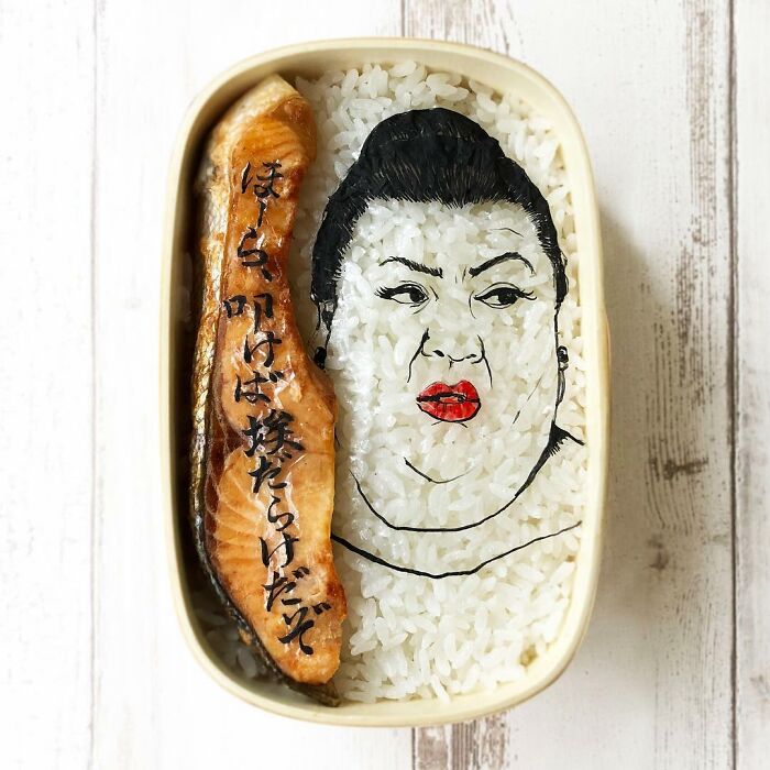 Bento artist creates detailed lunchbox featuring a face and salmon, inspired by favorite TV shows, movies, and manga.