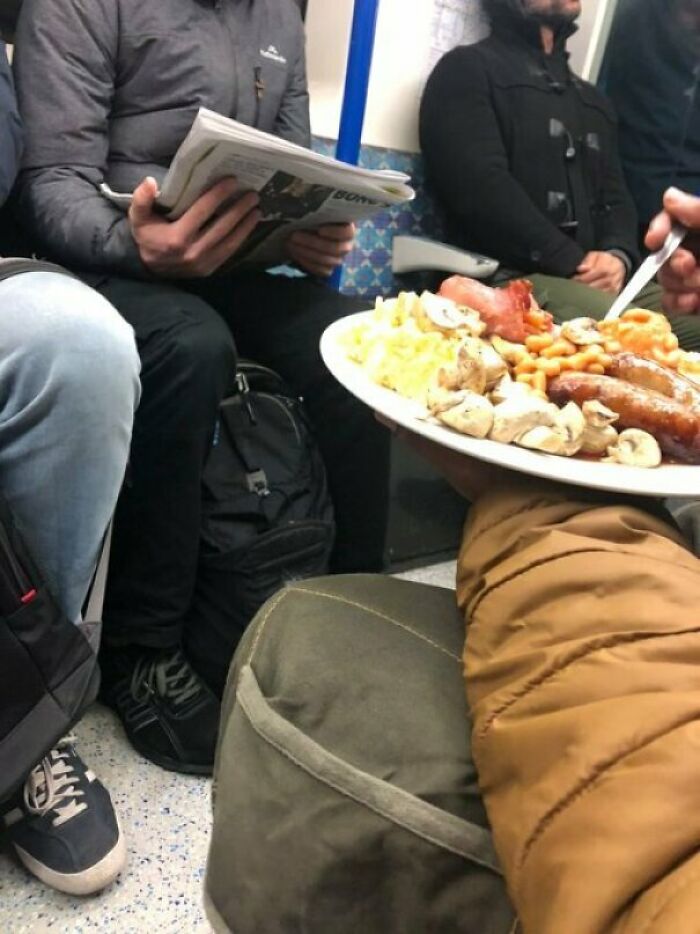 Un tipo comiéndose un desayuno inglés completo en el metro
