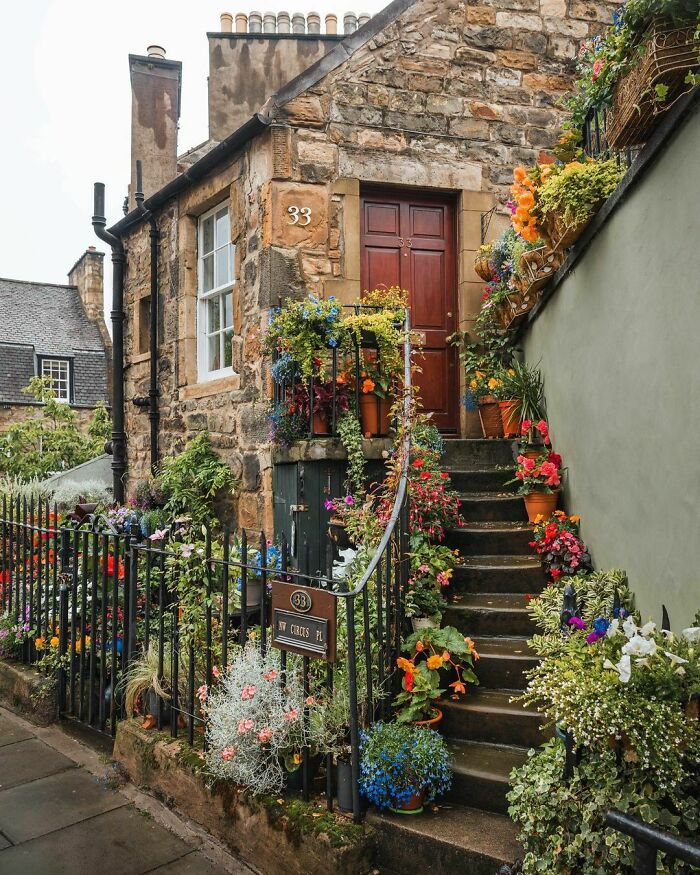 Entrance To A Stone Cottage Adorned With Flowers In Stockbridge, Edinburgh, Scotland