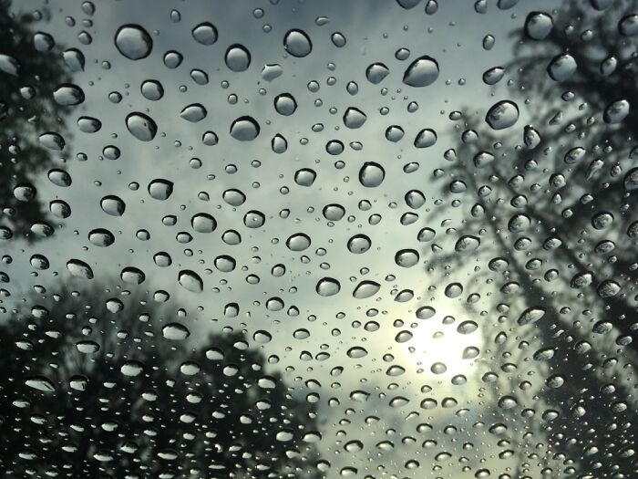 Raindrops On A Glass Pane With The Sun Behind Them..