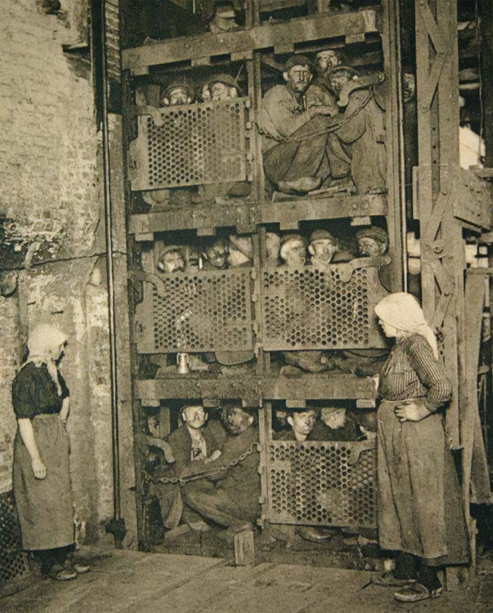 Mineros de una mina de carbón subiendo por un elevador luego de un día de trabajo en Bélgica, década de 1920