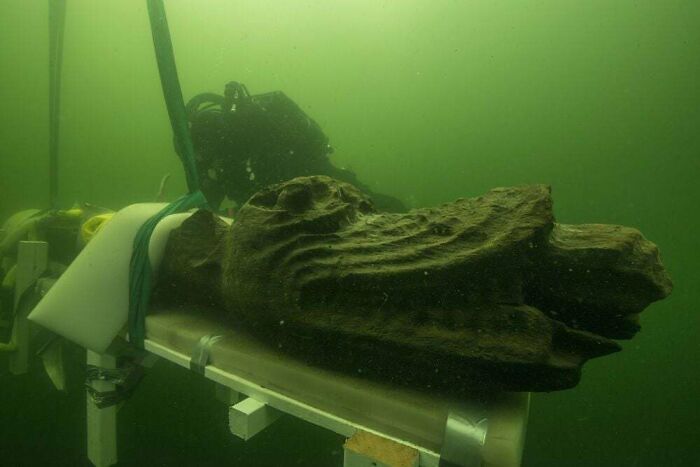 Carved Head Of A Sea Monster Rises From The Depths; A Figure Salvaged From The Gribshunden, A Warship That Sank In 1495