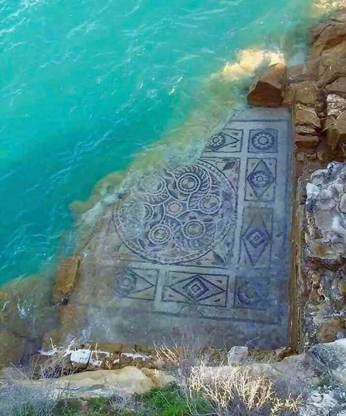 Intricately Designed Stone Slab Resting Just Below Water Level