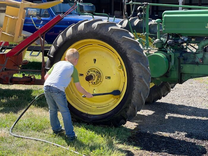 Our Grandson Cleaning Tractor Tires As We Begin Baling Hay.