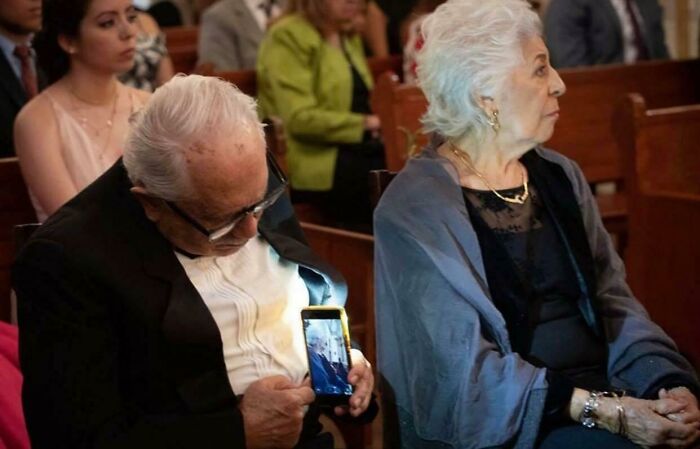 Un hombre mayor tomando una foto de su esposa sin que se dé cuenta